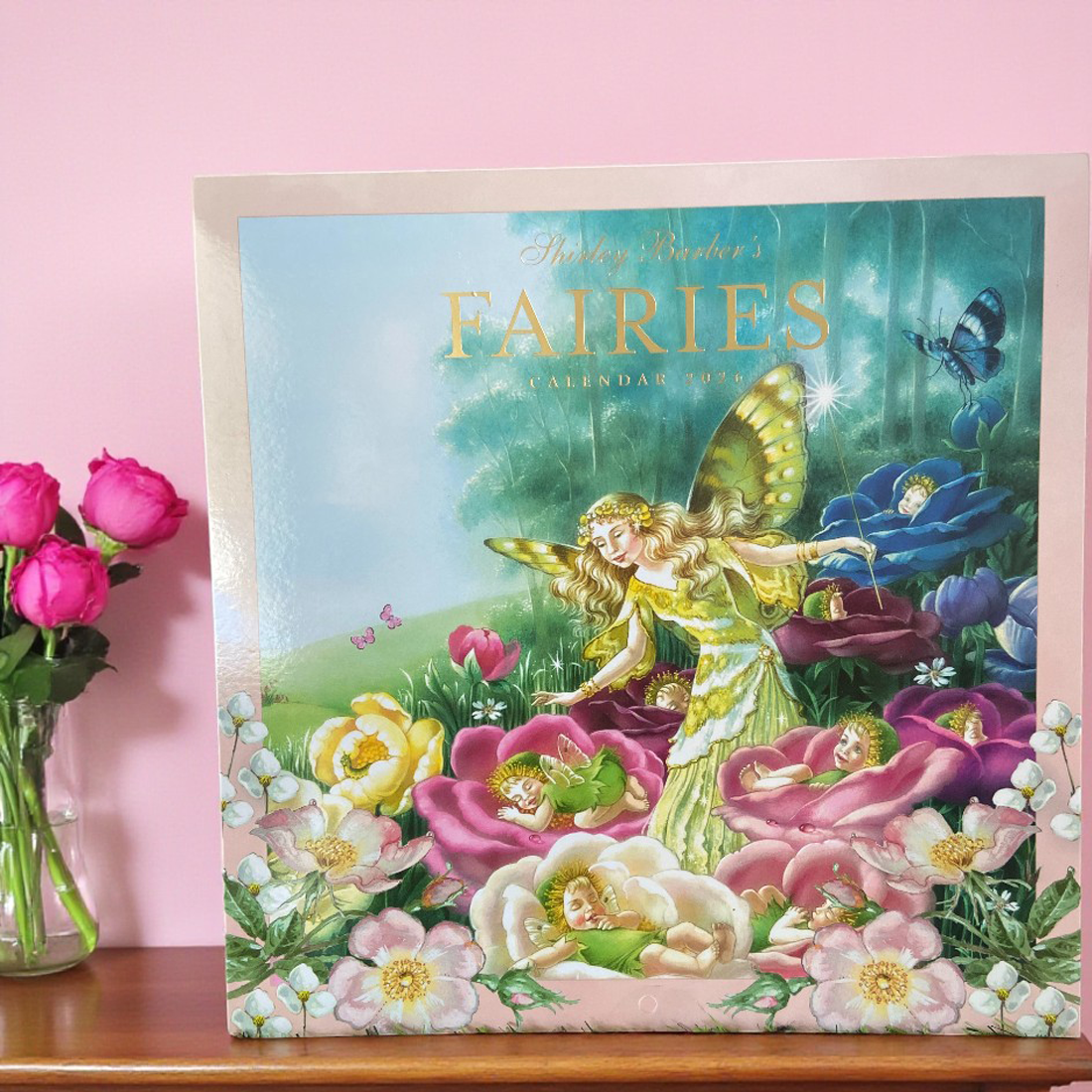 Calendar cover featuring a fairy among flowers on a pink background