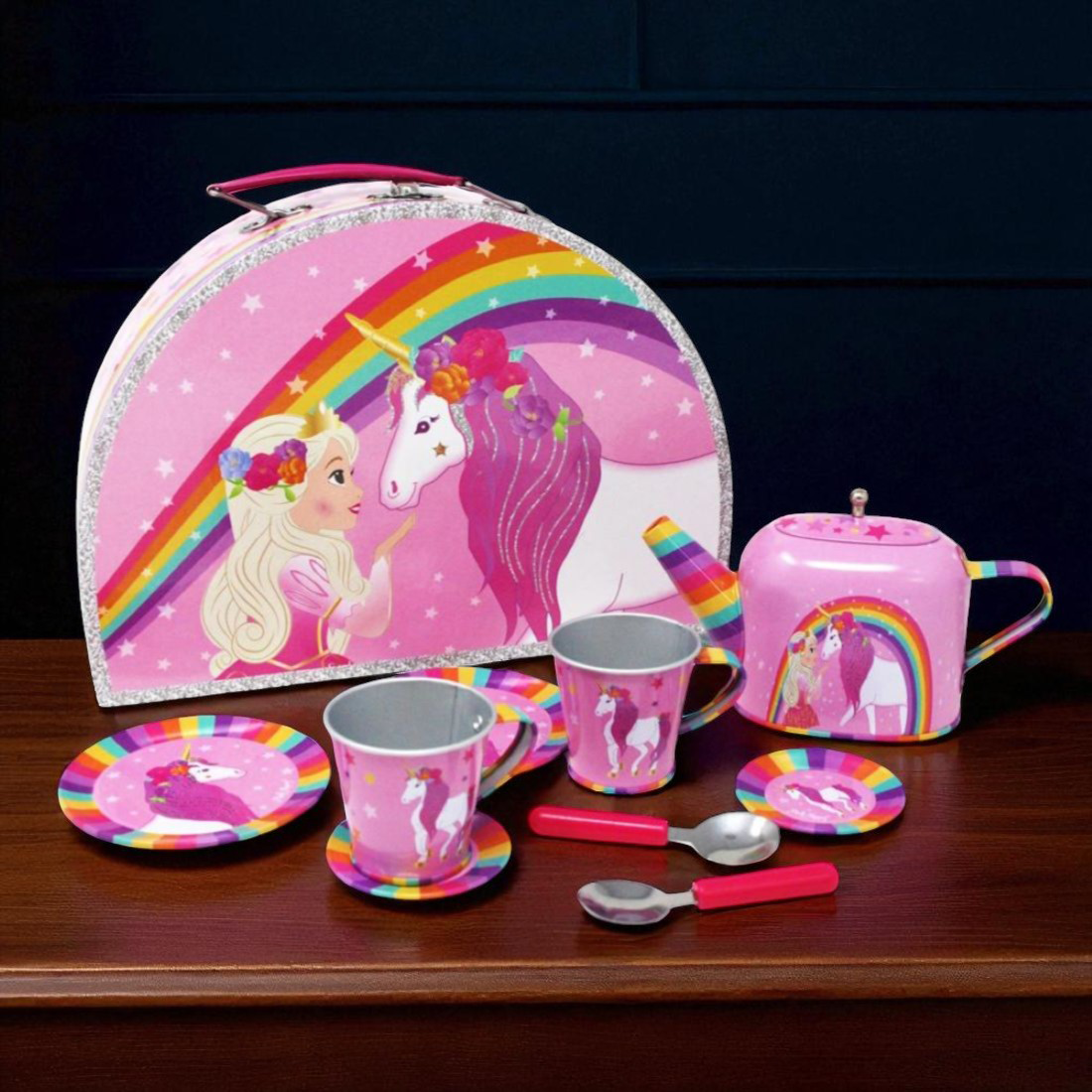 Children's tea set with pink case featuring a unicorn and rainbow design on a wooden surface.