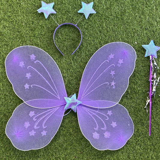 Purple fairy wings, headband, and wand on grass
