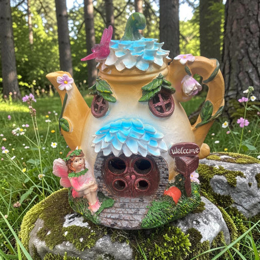 Fairy house made from a teapot in a garden setting