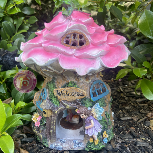 A pink petal-shaped solar-powered hollow home with fairies, suitable for indoor or outdoor use.