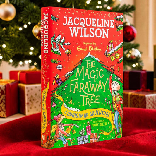The book 'The Magic Faraway Tree: A Christmas Adventure' by Jacqueline Wilson stands upright on a red fabric surface in front of a decorated Christmas tree and wrapped gift boxes. The cover is predominantly red with a large green tree illustration and colorful holiday artwork.