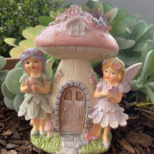 Gnome figurines with a mushroom-shaped house in a garden setting