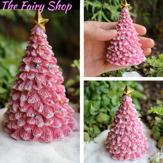 A pink miniature fairy garden Christmas tree with a golden star on top,