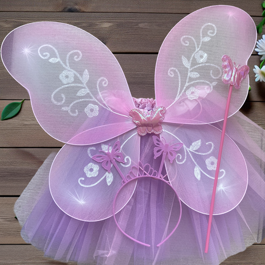 Pink fairy wings with decorative elements on a wooden surface