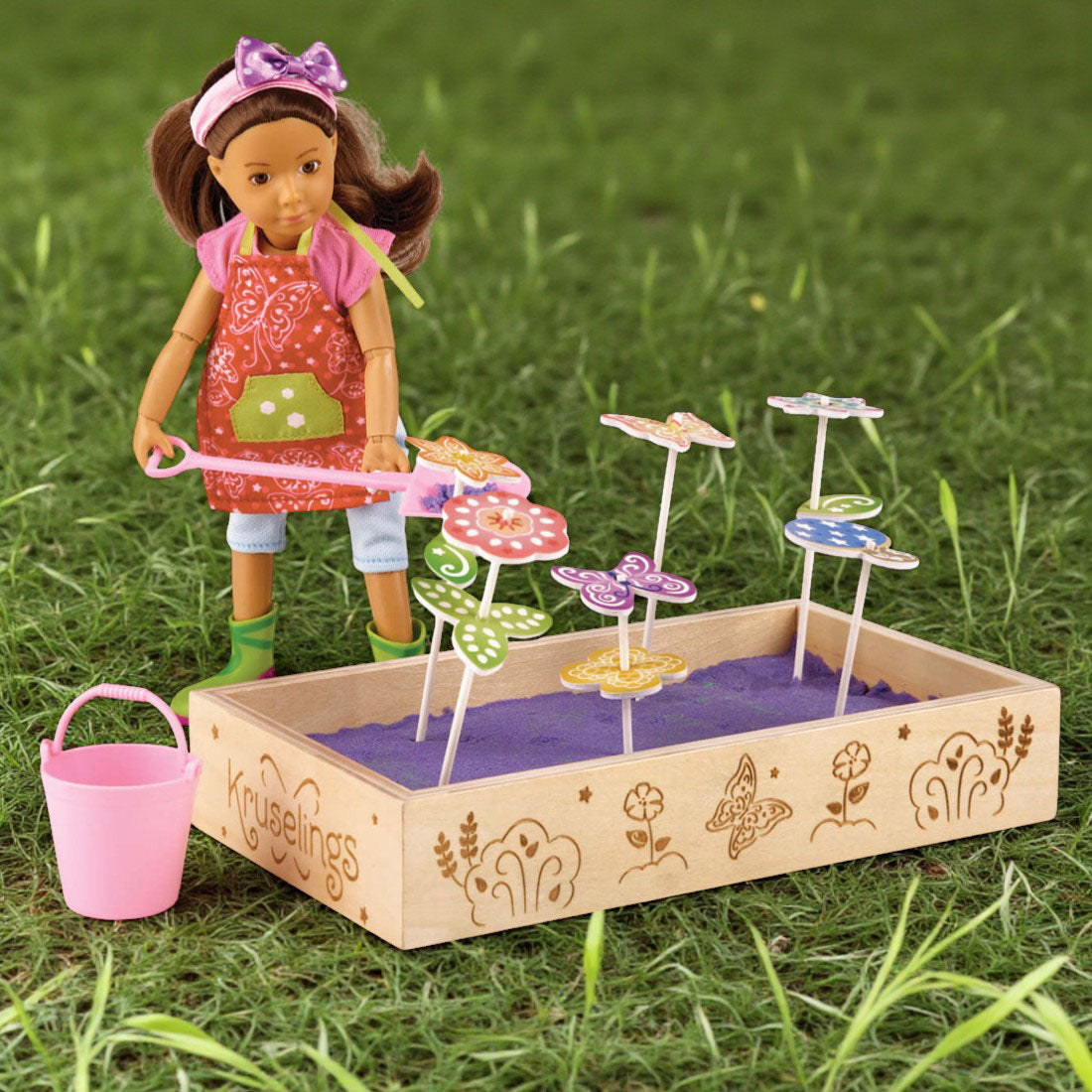 Doll with a garden playset on grass