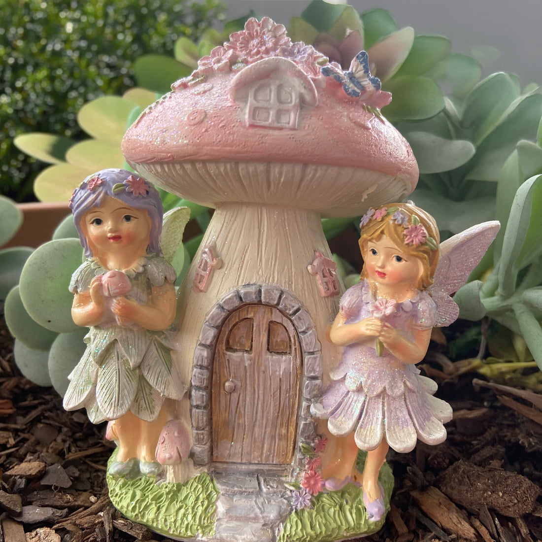 Gnome figurines with a mushroom-shaped house in a garden setting